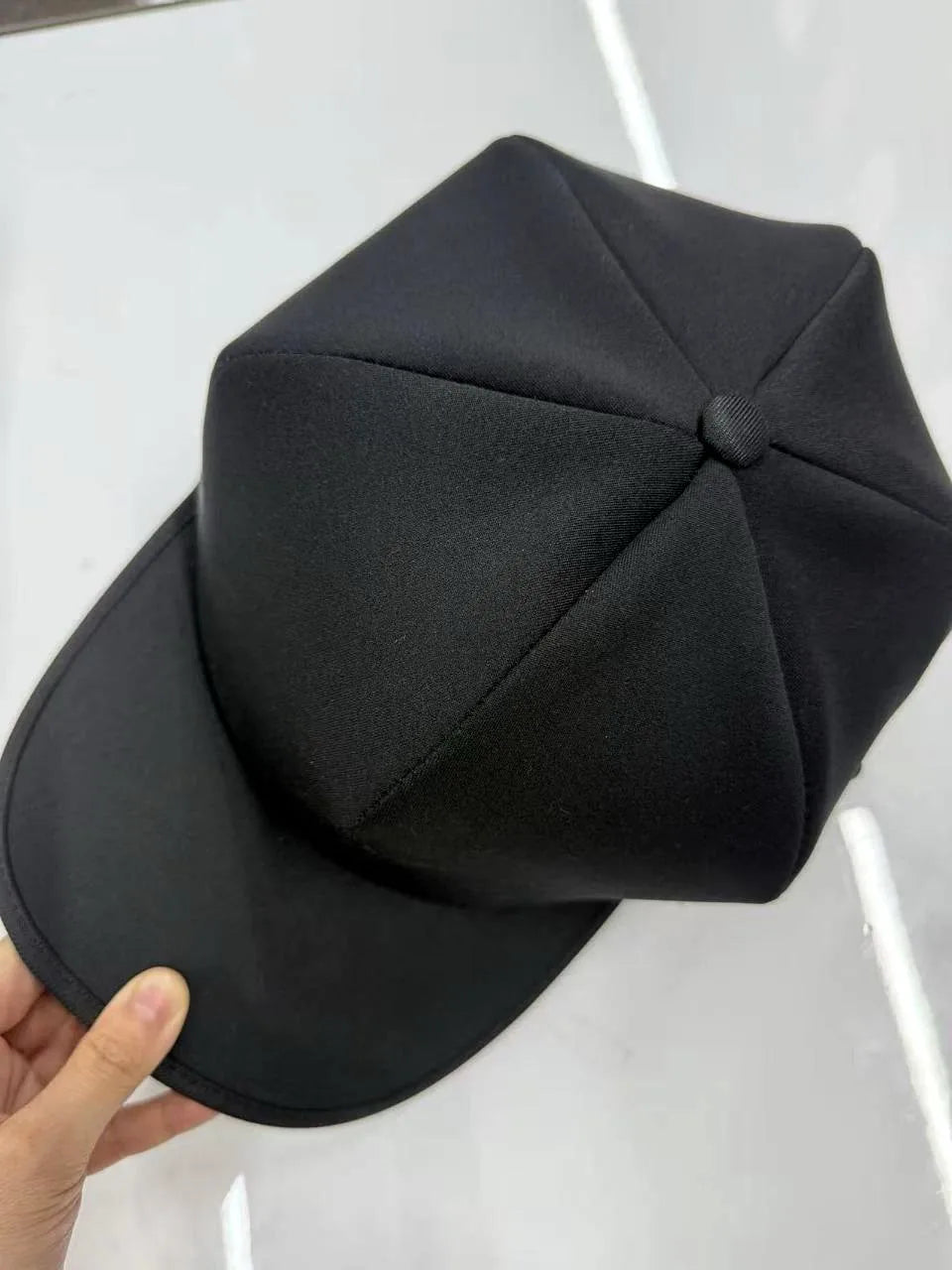 Exterior do boné preto RevitaHair com aba e painéis costurados